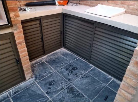 Detalle de bajo mesada de aluminio con puertas tipo celosía