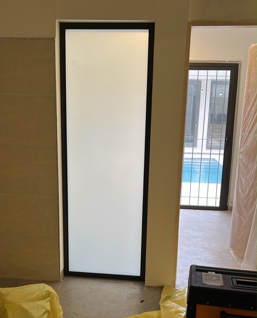 Paño fijo instalado con vidrio laminado opalino y perfilería bronce colonial